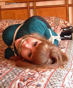 Darla Crane bound and gagged in a elbow tied hogtie with knotted scarf gag wearing a silk blouse and skirt